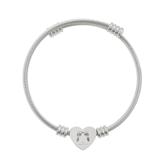 Silver cable bracelet with a heart-shaped charm featuring footprints on a white background