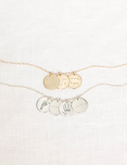 Gold and silver necklaces with engraved charms on a white background