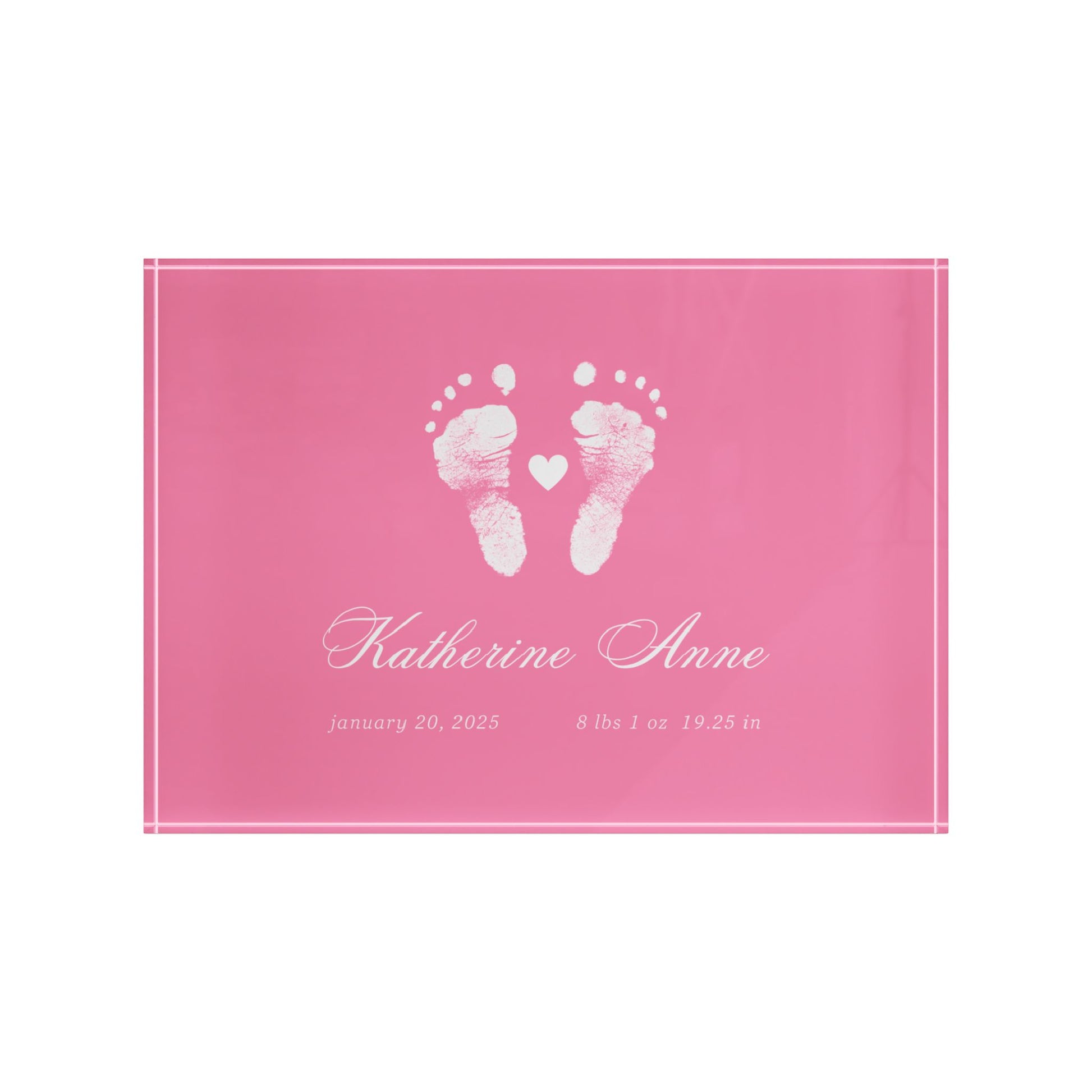 Pink acrylic block with white baby footprints and text